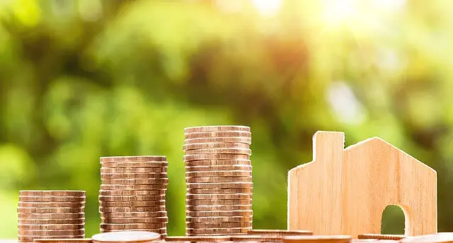 Casa de madera con monedas